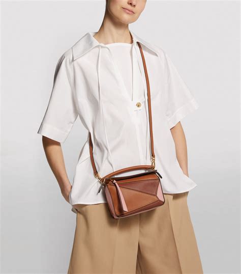 Loewe mini puzzle - Puzzle bag in satin calfskin. $3,900.00. Mini Puzzle Bumbag in classic calfskin. $2,100.00. Large Puzzle bag in classic calfskin. $4,100.00. See more products. Visit the original LOEWE website and browse premium Puzzle bags with latest designs of casual bumbags, crossbody bags and shoulder bags in a wide range of colors.